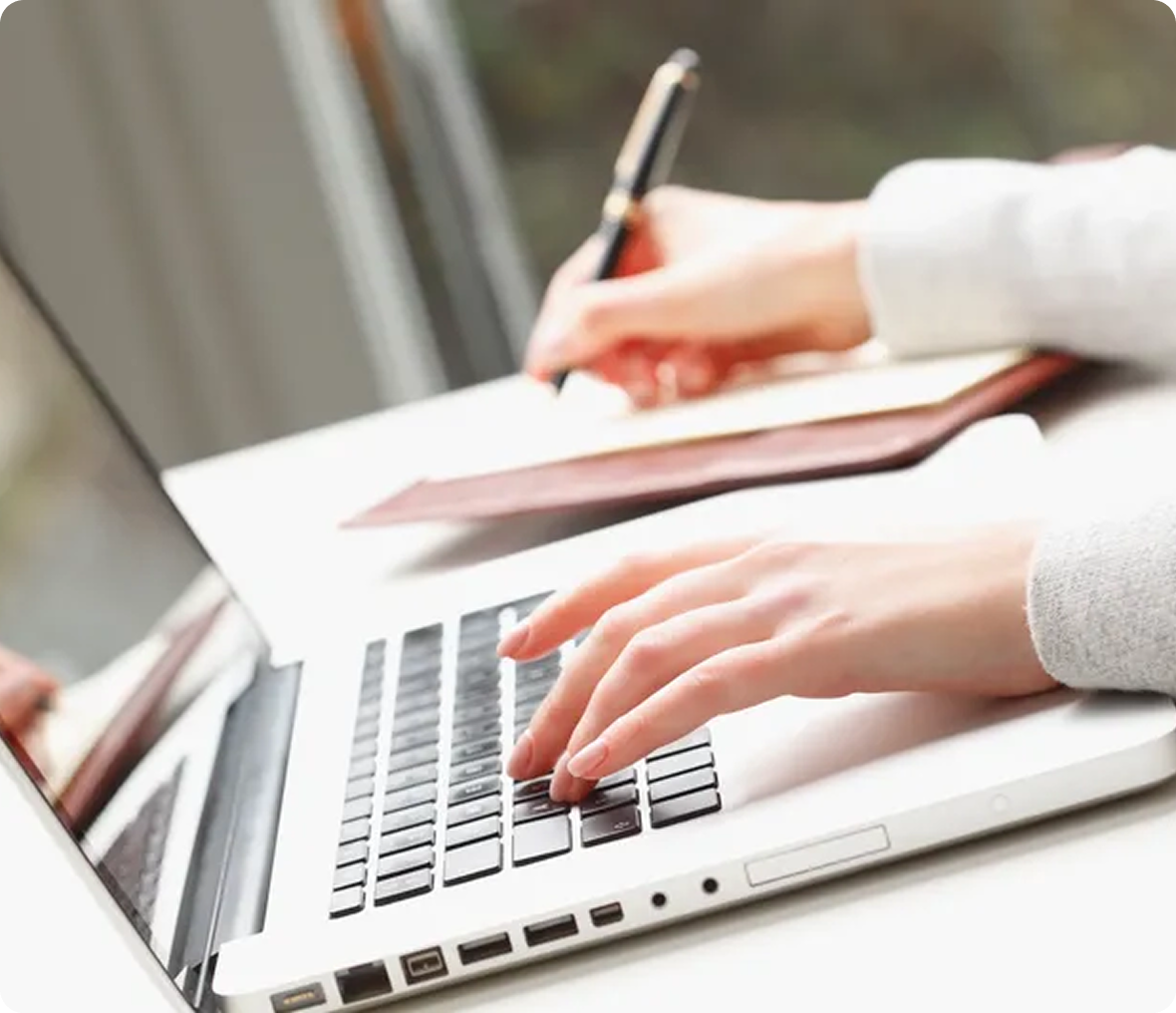Hands typing on a laptop keyboard