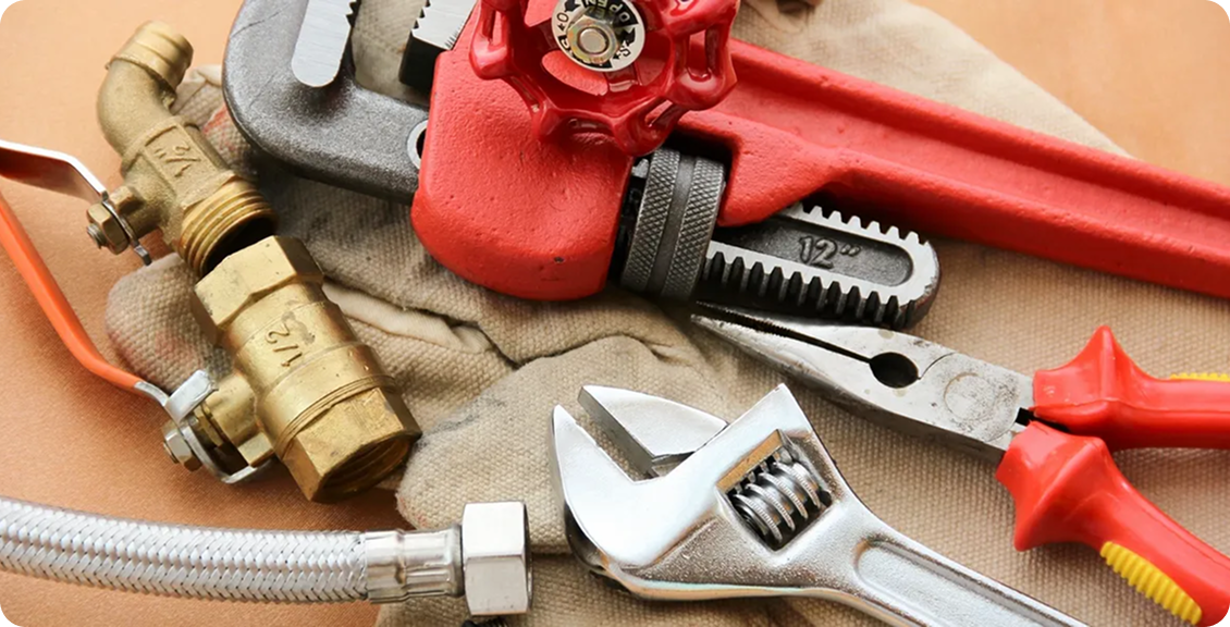 Pipe wrench and fittings on a work surface