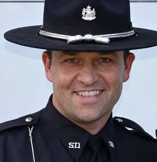 Officer in black hat smiling